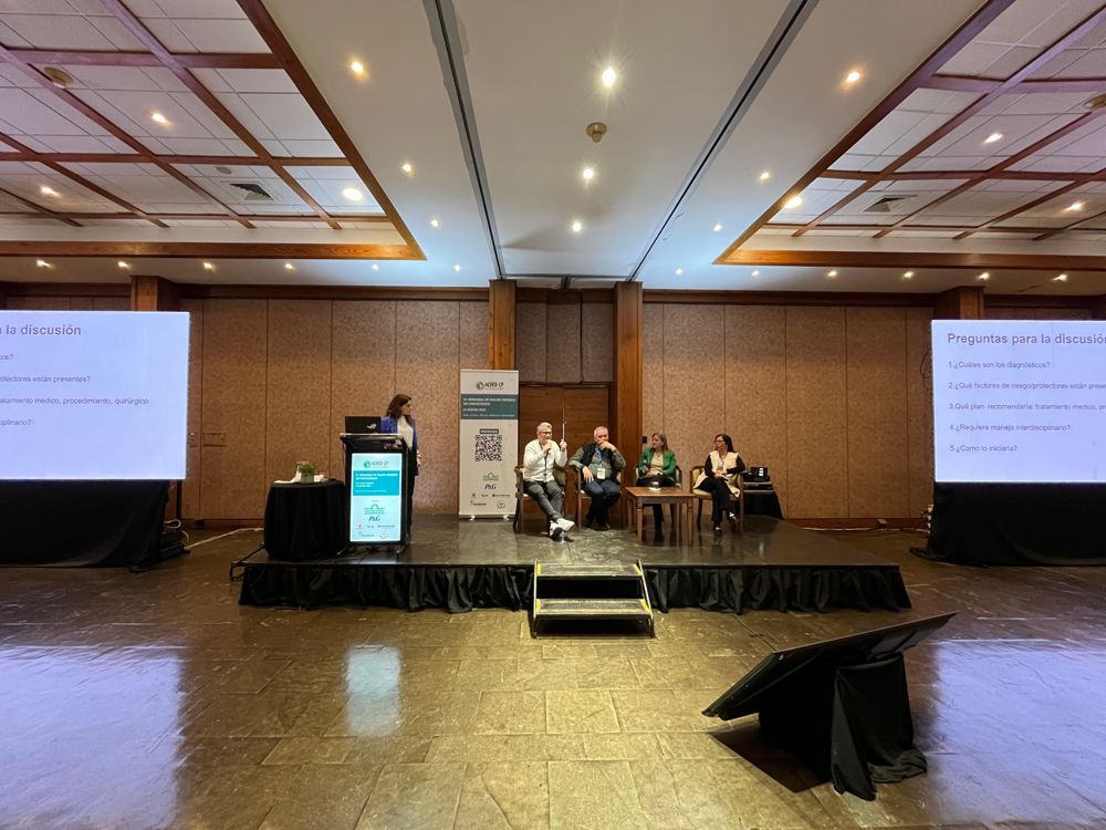 Mesa de discusión en escenario con pantallas laterales, Jornadas ACHED-CP La Serena 2025